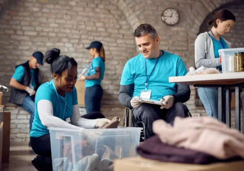 happy-volunteer-coordinator-in-wheelchair-supervis-2023-11-27-05-23-50-utc